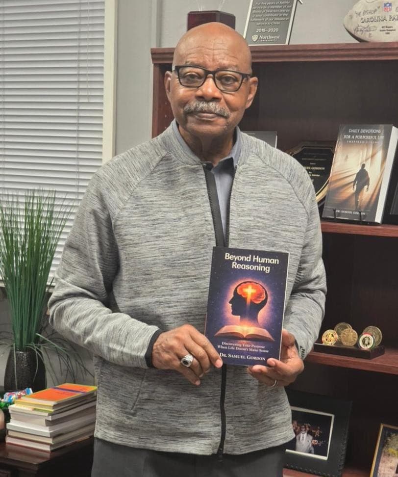 An author holding Beyond Human Reasoning in his office