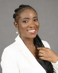 Portrait of a smiling woman in a white blazer with long braided hair